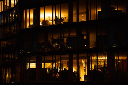 Office building exterior with glowing lights in windows at night city. Vienna city downtown district...
