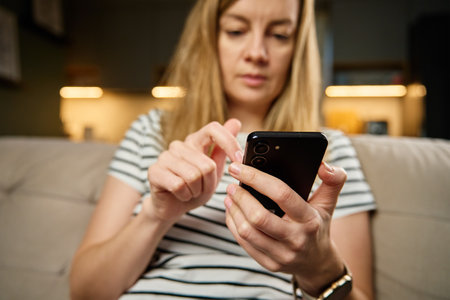 Person casually using smartphone with social media feed displayed on screen, suggesting engagement...