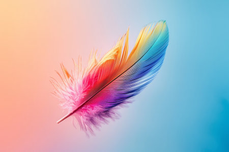 Colored bird feather floating in air on gradient backgroundの素材
