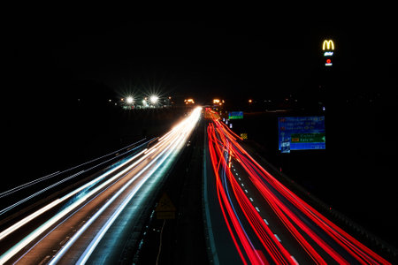 Light trails on the highway at night and McDonalds logo with McCafe sign. Roadside service. Katy Wroclawskie, Poland - February 9, 2024のeditorial素材