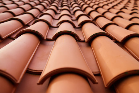Red ceramic roof tiles covering residential building roof. Tile pattern close-upの写真素材