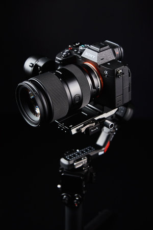 Sony camera mounted on DJI RS4 gimbal on dark background. Camera stabilization technology....