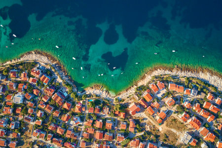 Aerial top view of seashore with turquose water and coastal city with red-roofed houses. Panorama of tourist town Rogoznica in Croatia on Adriatic Sea. Summer vacation and travel conceptの写真素材