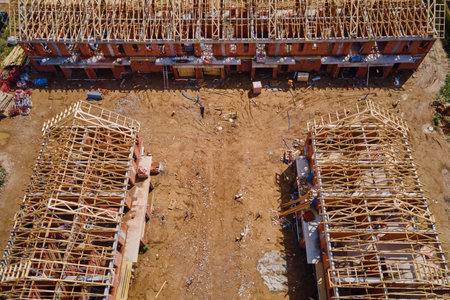New house under construction, wooden truss system forming roof. Process of building project.