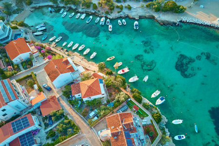 Birds eye view of sea coast with small town along seashore. Aerial top view of coastal village with...