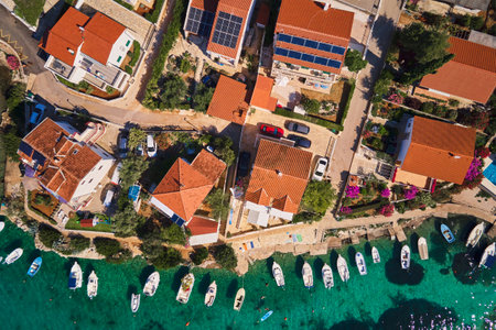 Birds eye view of sea coast with small town along seashore. Aerial top view of coastal village with red-roofed houses and boats near shore. Tourist town Rogoznica in Croatia on Adriatic Seaの写真素材