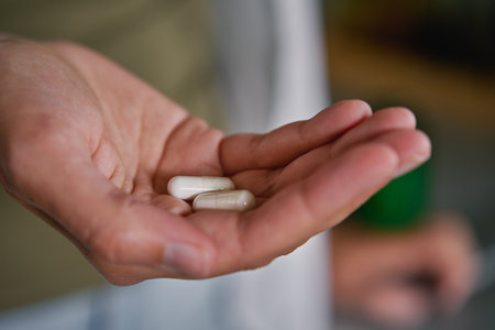 Woman holds pills in hand. Person takes dietary supplements and vitamins. Daily medical procedure to maintain healthの写真素材