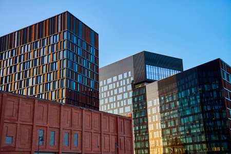 Modern glass office buildings reflecting city skyline in windows at sunset. Contemporary...