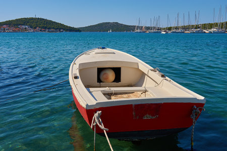 Small fishing boat on transparent turquoise water surface on sunny summer day. Vessel in sea. Summer vacation and tourism conceptの写真素材