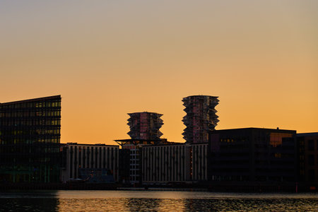 Silhouetted cityscape with contemporary buildings and contemporary architectural design at sunsetの写真素材