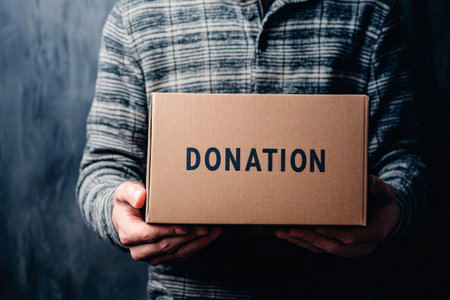 Volunteer holding cardboard donation box. Concept of charity, giving and community supportの素材
