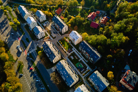Aerial view of modern residential neighborhood with contemporary apartment buildings, green spaces, parking areas and well-maintained pathways on sunny dayの写真素材