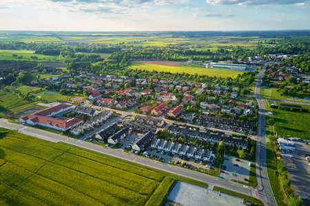 Aerial view of suburban town with houses, residential blocks, roads and farmland. Panoramic view of European neighborhood at sunsetの写真素材