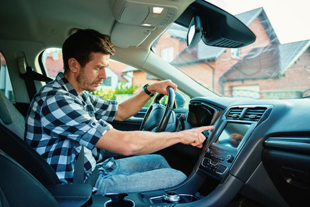 Man sitting in car and pressing engine start button. Starting vehicle using modern ignition technology. Person ready to driving carの写真素材