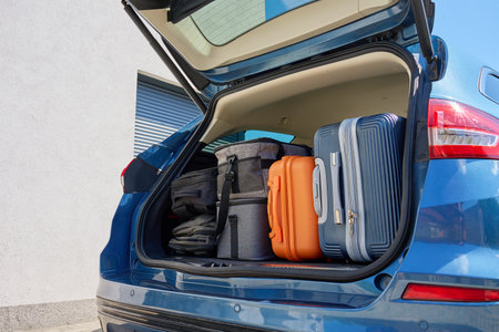 Full car trunk packed with suitcases, backpacks and bags. Vehicle filled with luggage ready for travel. Moving or road trip conceptの写真素材