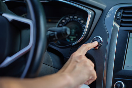 Close-up of hand pressing start button to turn on car engine. Keyless ignition system in modern carの写真素材