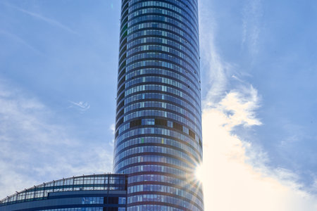 Modern glass skyscraper with curved facade reflecting sunlight and blue sky. Sky Tower building in Wroclaw, Poland. Contemporary architectureの写真素材