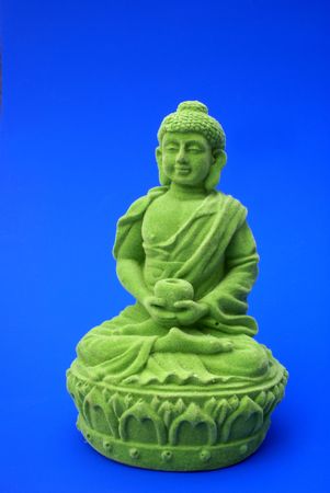 Green buddha against a blue background.の写真素材