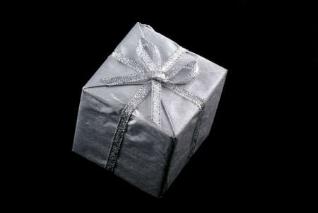 Silver christmas present, isolated on black.                 の写真素材