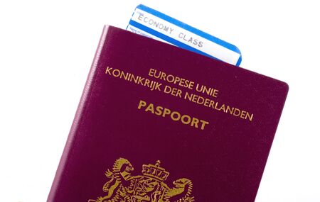 Economy plane ticket in dutch passport isolated on white.の写真素材