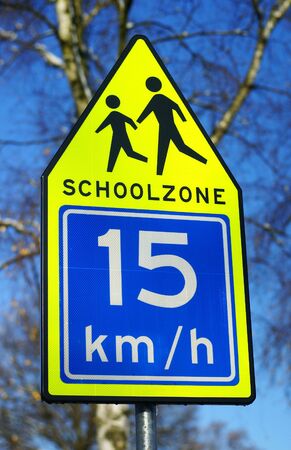 Schoolzone traffic sign against a blue sky.の写真素材