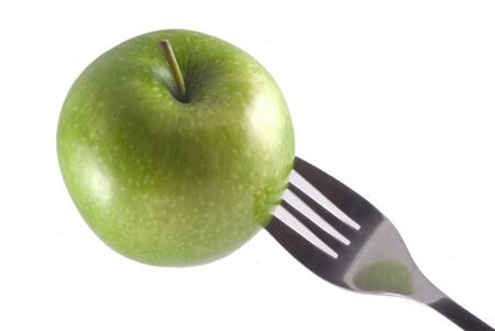 A green apple stuck on a fork, isolated on white.の写真素材