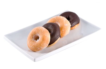 Fresh donuts on a white square plate, isolated on a white backgroundの写真素材
