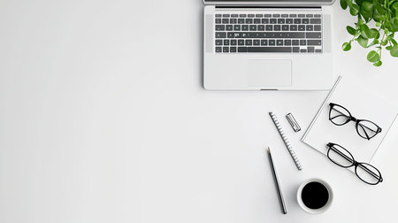 Laptop on a white table with a sleek modern design, surrounded by office supplies in a minimalist environmentの素材