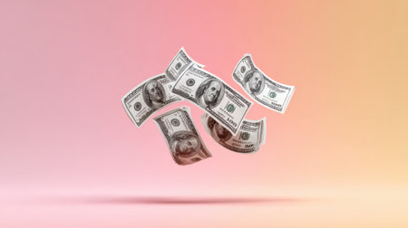 Play money bills flying in the air over a colorful background, representing fun and imaginationの素材