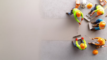 A team of construction workers finishing a concrete driveway with smooth trowels.の素材