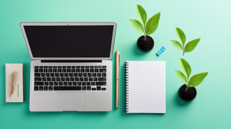 A flat lay of office essentials, including a laptop, notebook, and pen, symbolizing professional growthの素材