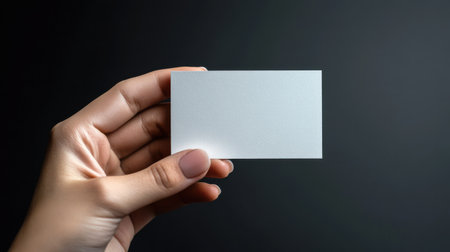 A blank business card held by a hand in a minimalistic settingの素材