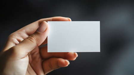 A blank business card held by a hand in a minimalistic settingの素材