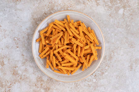 Gray plate of spicy tasty chips on marbles surface. High quality photo