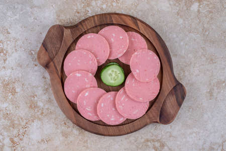 Wooden plate of delicious sliced sausages on marble surface. High quality photoの写真素材