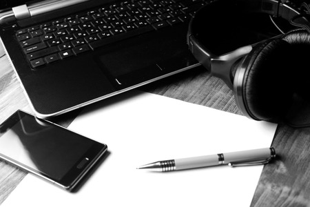Smartphone, Headphones and Laptop on a wooden Desktop.のeditorial素材
