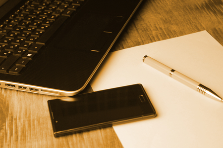 Business smartphone on the keyboard, with penのeditorial素材