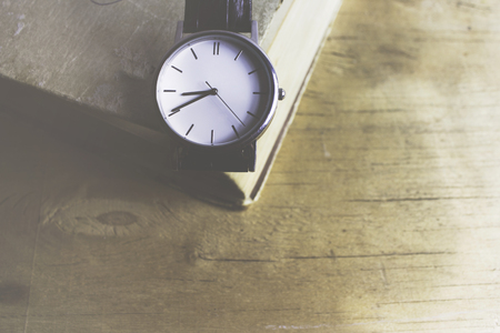 watch on the book lies in the wooden tableの写真素材