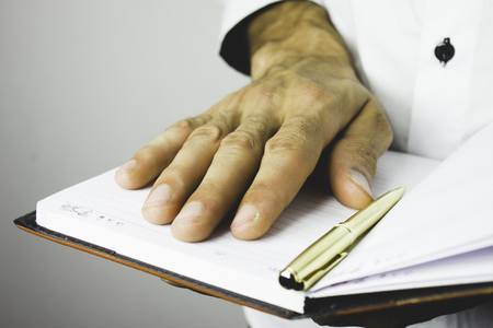 businessman holding diary in hands and hangsの写真素材