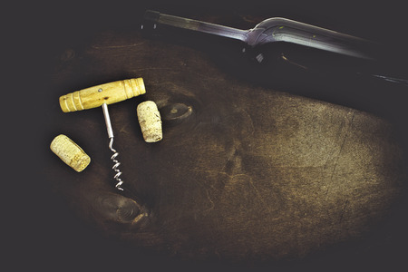 Red wine bottle and glass of wine on the dark wooden backgroundの写真素材