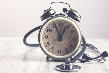alarm clock and stethoscope on the tableの写真素材