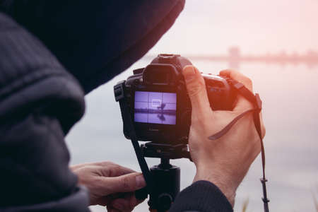 young photographer takes pictures of the lake