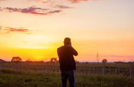 man takes a sunset photoの写真素材
