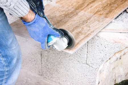 the tiler cuts tiles professionally and efficiently with an angle grinderの写真素材