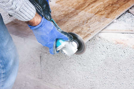 the tiler cuts tiles professionally and efficiently with an angle grinderの写真素材