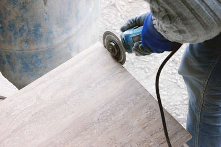 the tiler cuts tiles professionally and efficiently with an angle grinderの写真素材