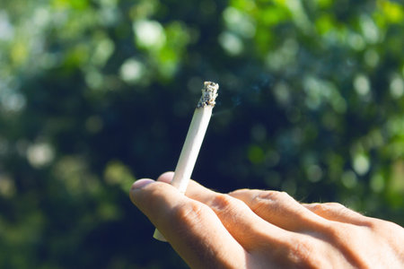 young guy holding a cigaretteの写真素材