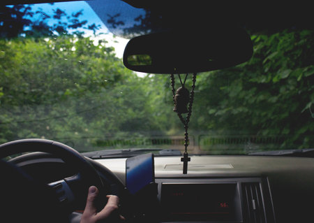 car on a dirt road among forest treesの写真素材