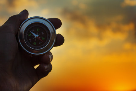 Compass in hand on a background of natureの写真素材
