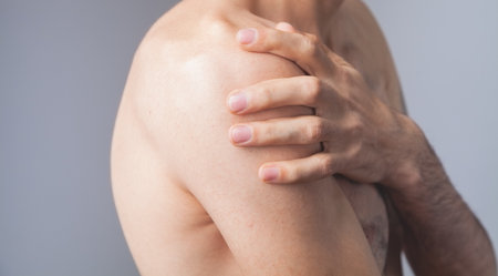 man holding his shoulders shoulder pain